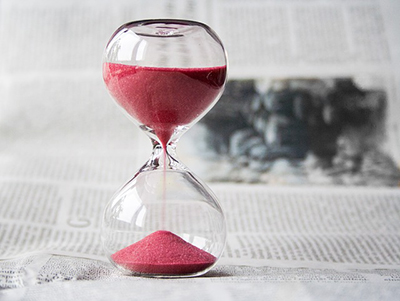 Sand slipping through an hourglass reminds us that time Management is essential.